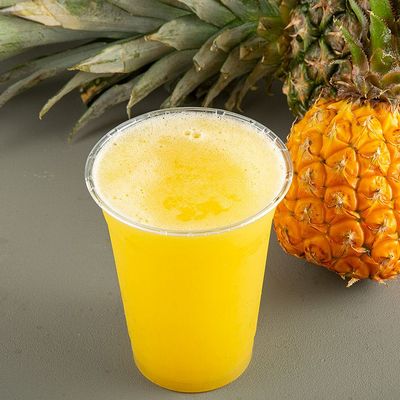 A cup of pineapple pieces with juice