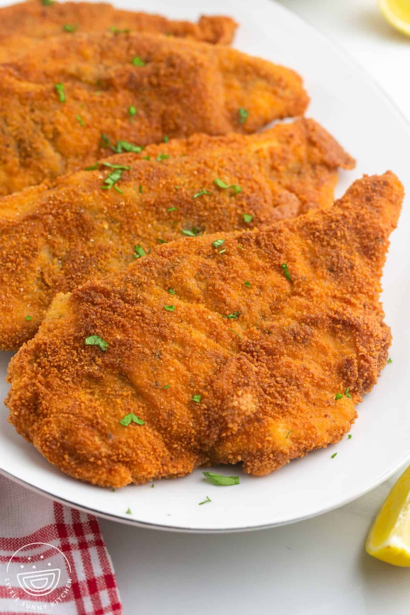Pane chicken dish served with pasta and potato