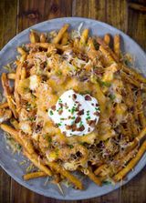 French Fries With Chicken Pieces And Cheddar Cheese Sauce