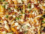 French Fries With Chicken Pieces And Cheddar Cheese Sauce And Jalapeno Sauce