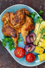 Whole grilled chicken on charcoal with extra