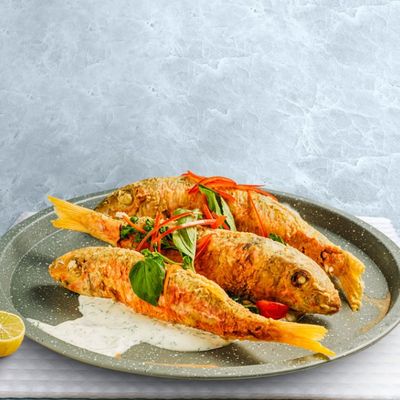 Fried barbouni fish, sour cream, cherry tomatoes onion and parsley served with jasmin rice