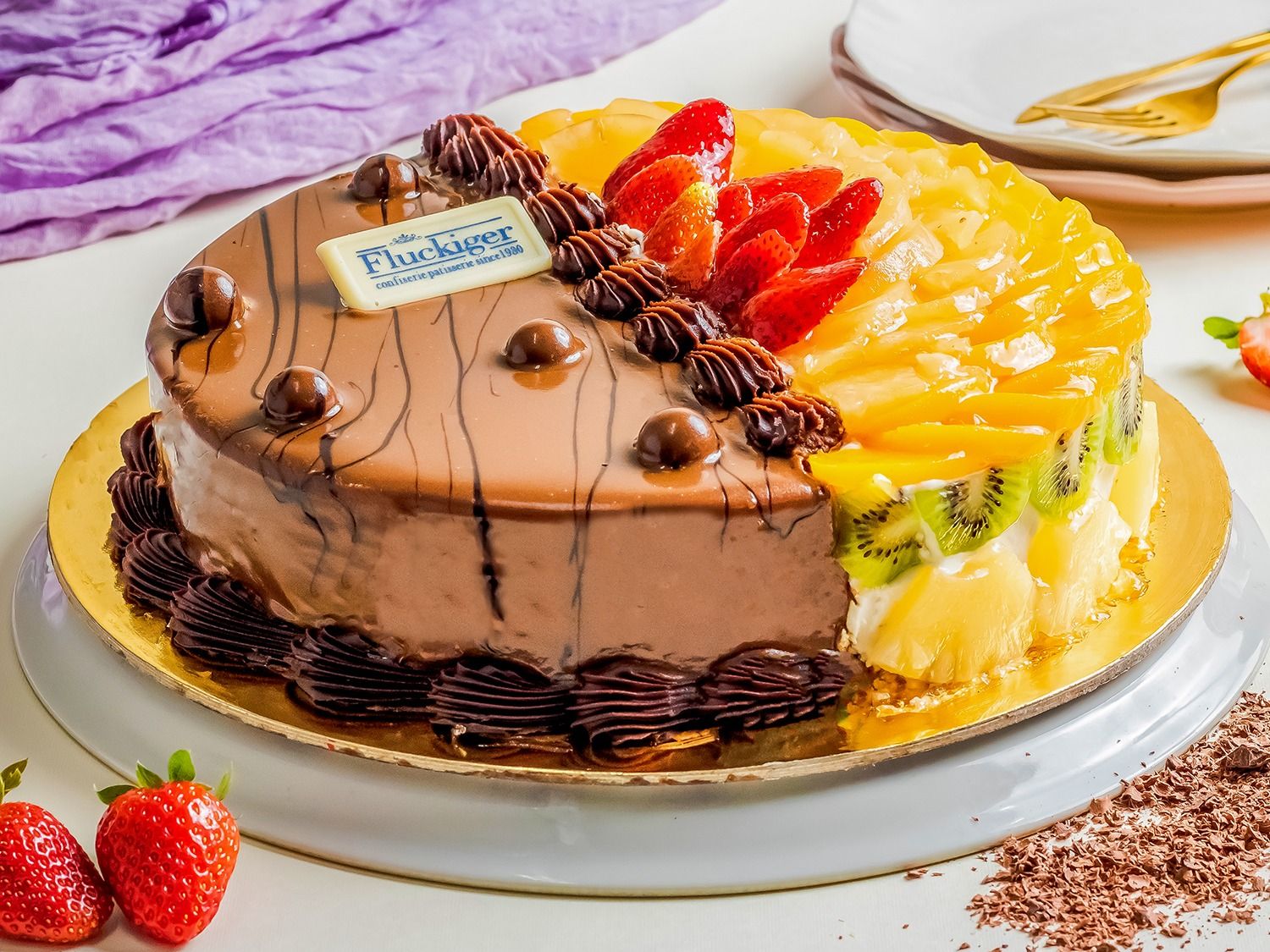 Half chocolate, half cream cake with fruits