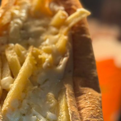 بطاطس مقلية مع جبنة في ساندويتش خبز فرنسي
