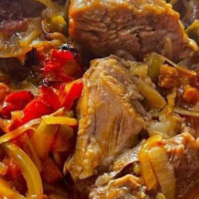A Dish Of Diced Meat With Onions And Peppers